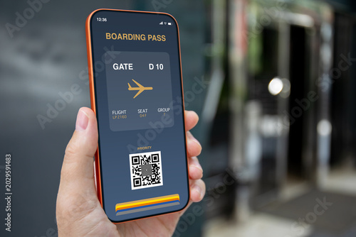 Man hand holding phone with digital boarding pass at airport