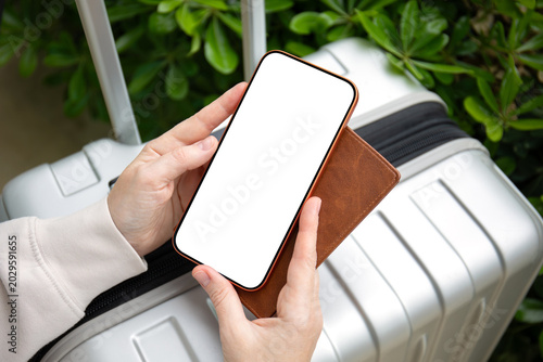 female hands holding orange phone with isolated screen suitcase airport
