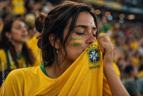 Passionate brazilian soccer fan kissing the national team jersey in stadium