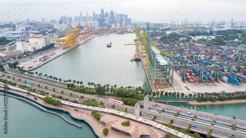 Aerial View of Busy Industrial Container Port with City Skyline Background