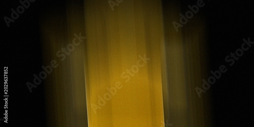 Fotografía Abstract vertical golden yellow light streaks on black background with motion blur effect and grainy texture