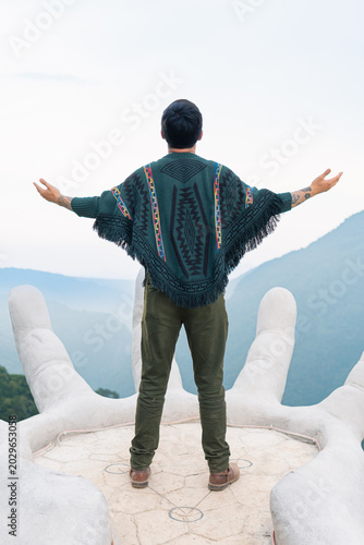 Man wearing poncho standing on giant hand matliwaka zacatlan
