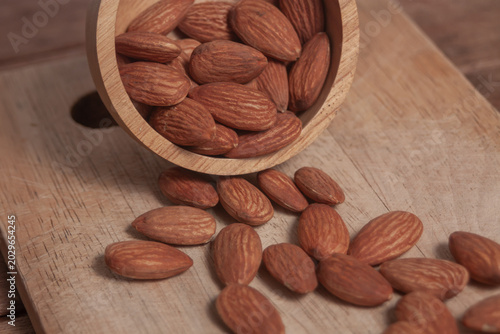 Almonds rest on a simple piece of paper, highlighting their natural texture in a clean minimal scene.