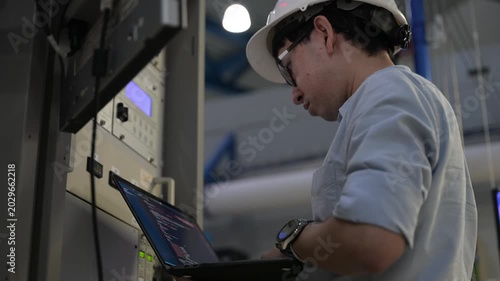 Electrical engineer male checking voltage at the Power Distribution Cabinet in the control room,preventive maintenance Yearly,inspecting power system and control panel in industrial factory
