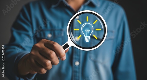 Innovation concept hand holding magnifying glass over glowing lightbulb illustration