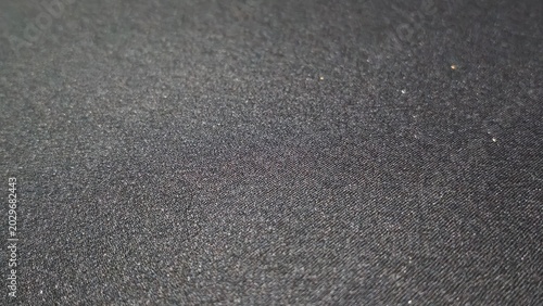 Fotografija Dark asphalt texture with rough granular surface and subtle lighting