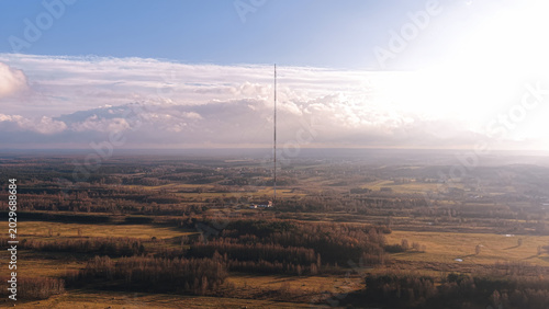 Signal tower above farmland and distant horizon