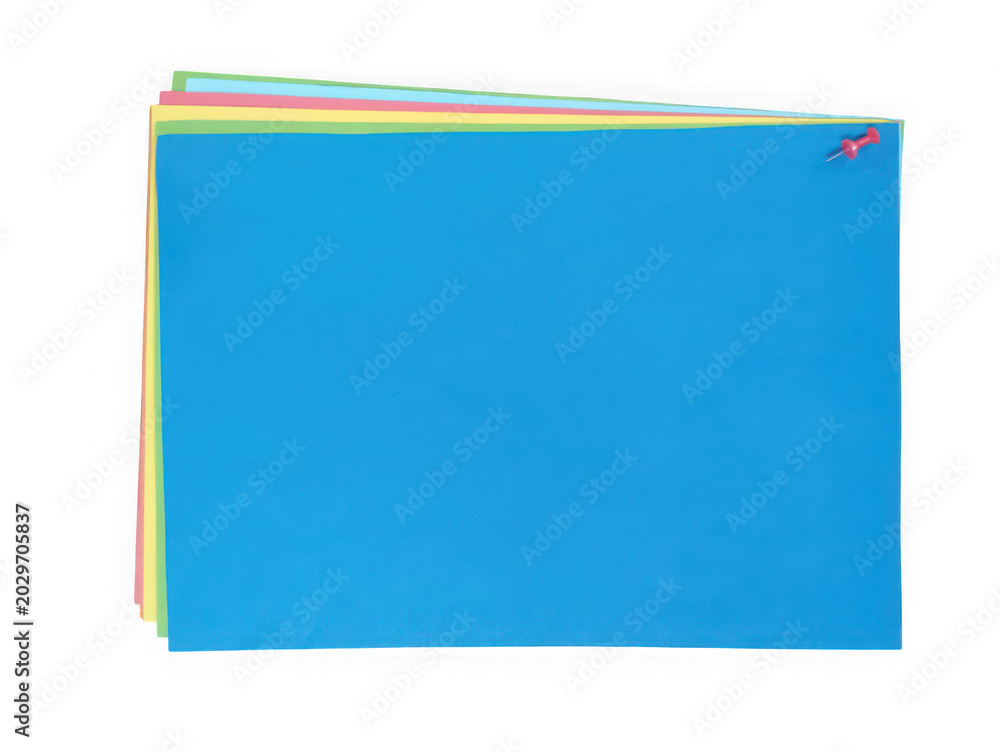 Fototapeta premium Stack of colorful paper sheets with a red push pin isolated on white background
