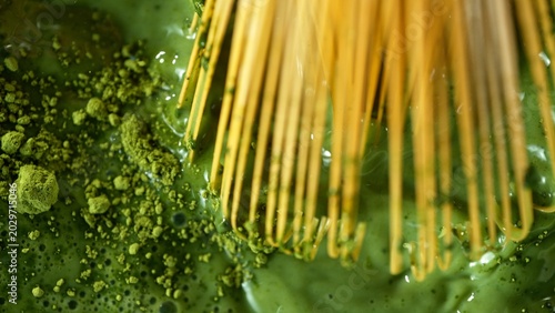 Bamboo Whisk Mixing Matcha Tea in Macro