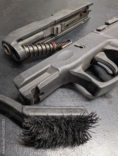 Canvas Print Disassembled polymer handgun parts with slide, recoil spring, and nylon brush prepared for thorough firearm cleaning and maintenance routine