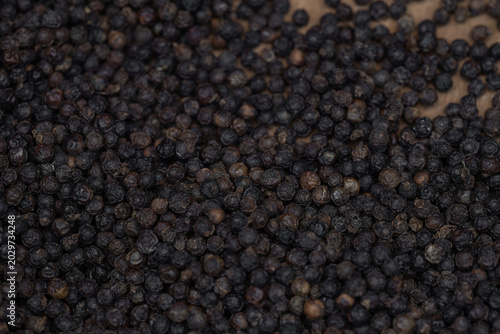 Canvas Print A close-up, overhead shot showcases a generous pile of dark, textured black peppercorns