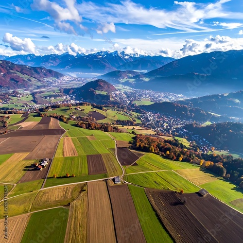 Aerial view of rural landscape with fields and mountains.