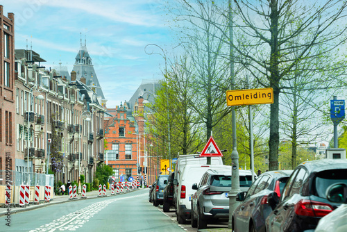 Yellow road sign reading Omleiding (Detour) due to roadworks on a street in Amsterdam (Amsterdam), Netherlands