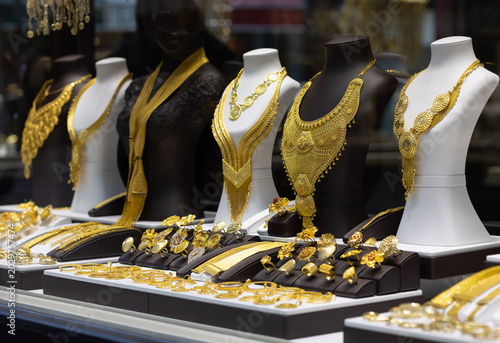 Obraz na plátně luxurious display of ornate 22k gold bridal necklaces and intricate filigree rings on mannequins in a high-end jewelry boutique window