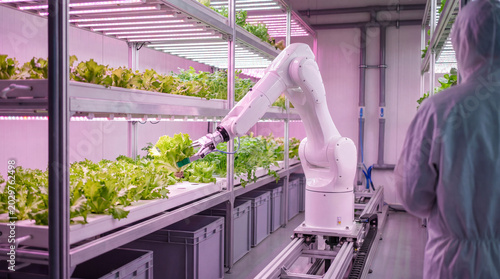 Foto Robotic arm precisely harvesting fresh green lettuce plants in a controlled indoor vertical farm setting