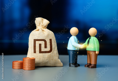 Fotografie Businessman shaking hands and Israeli shekel money bag