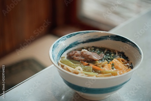 Bowl of chicken noodle soup with blurred background