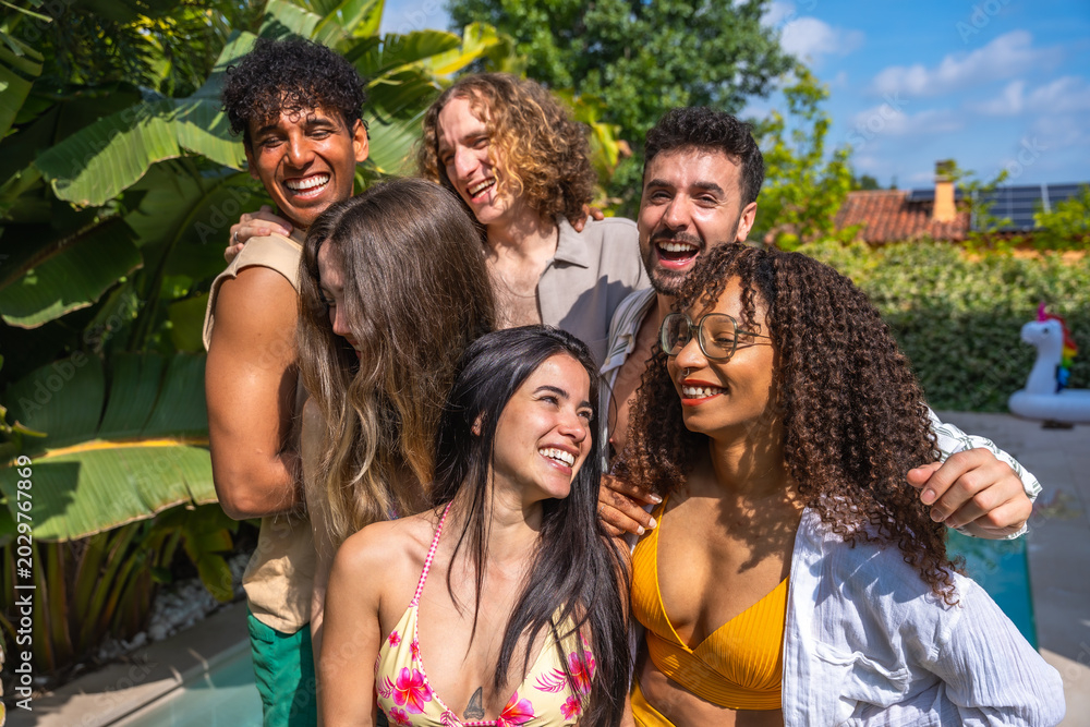 Fototapeta premium Diverse friends laughing and hugging at summer pool party
