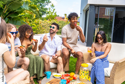 Schilderij op canvas Diverse friends sharing food and drinks at outdoor summer party
