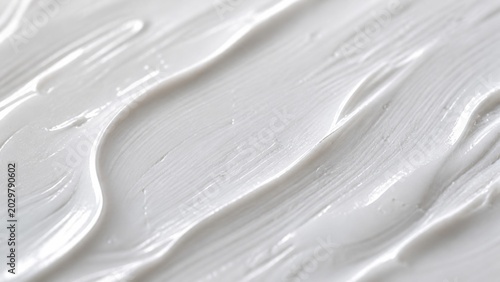 White cream texture with smooth wave lines showing a thick lotion or paint surface for beauty product