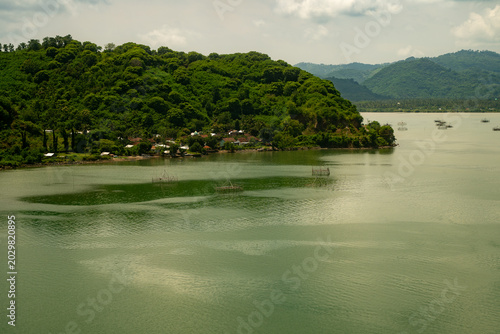 Quadro su tela Tropical harbor view with lush green hills at Lembar Port, Lombok, Indonesia