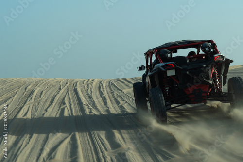 Fotografi Speed motion blur of a dune buggy carving through sand tracks at Khor Al Adaid desert safari