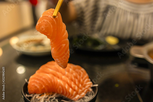 Fresh salmon sashimi delicately placed on ice, symbolizing Japanese culinary artistry and freshness in every bite