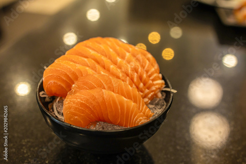 Fresh salmon sashimi delicately placed on ice, symbolizing Japanese culinary artistry and freshness in every bite