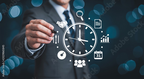 Businessman pointing at clock icon with financial management symbols representing effective time tracking and corporate productivity.