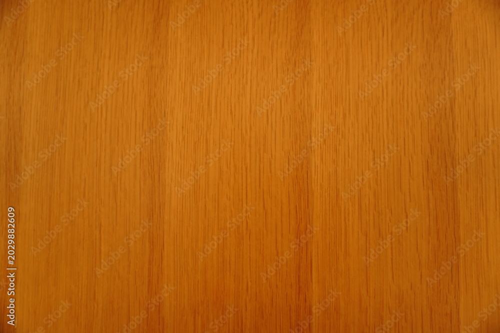 Fototapeta premium Top view of a polished light brown wood grain surface with uniform vertical patterns and warm amber tones