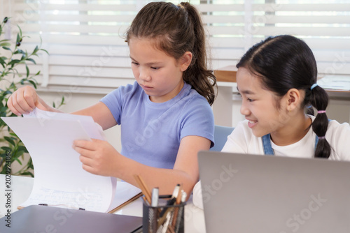 Canvastavla Caucasian preteen girl checking paper homework while asian classmate smiling bes