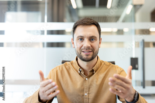 Obraz na plátně Mid-adult businessman confidently explaining and gesturing during a professional