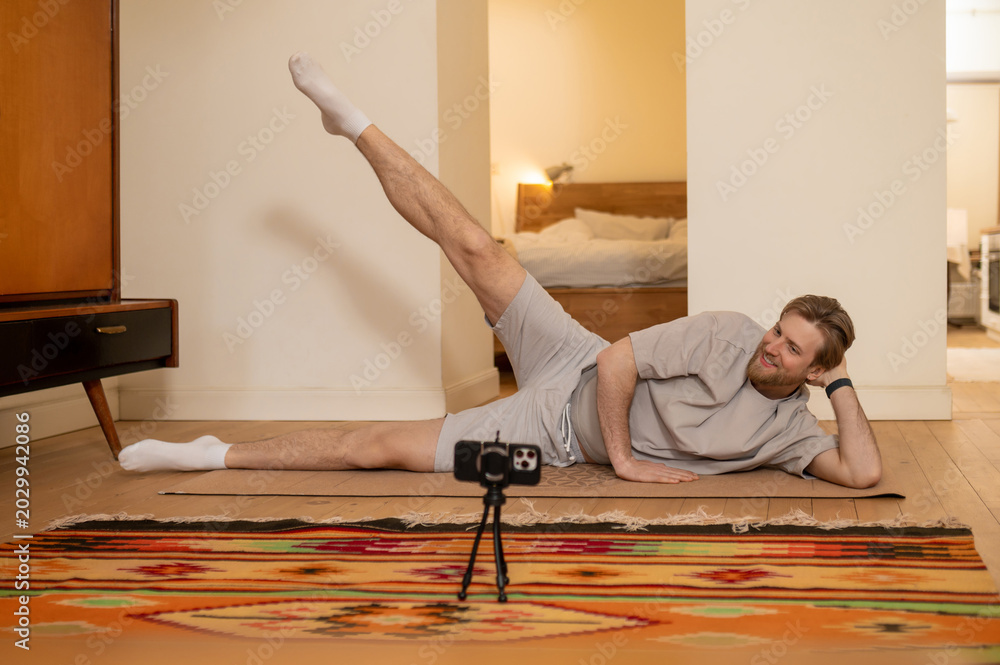 Φωτογραφία Young man having online yoga class and exercising at home