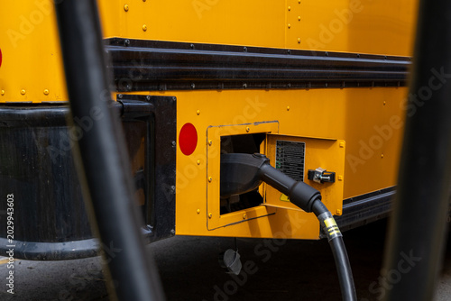 Electric school bus charging port connected to a power cable for clean energy
