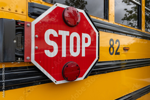Schilderij op canvas School bus stop sign extended for passenger safety during boarding and disembark