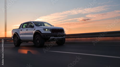 Cuadro en lienzo White pickup truck driving at sunset on highway road