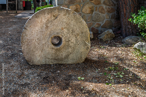 Bild auf Leinwand Antique Circular Stone Millstone Resting on Ground