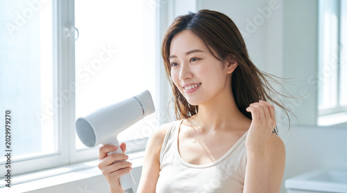 Plakat w ramie ドライヤーで髪を乾かす若い女性 ヘアケア