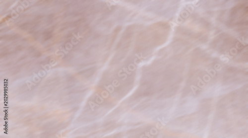 Photos A close-up, blurred shot of a marble surface with delicate pink and white veinin