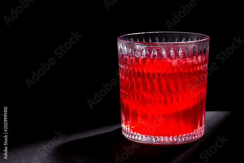 Foto Glass with red drink in medium close-up with lateral negative space
