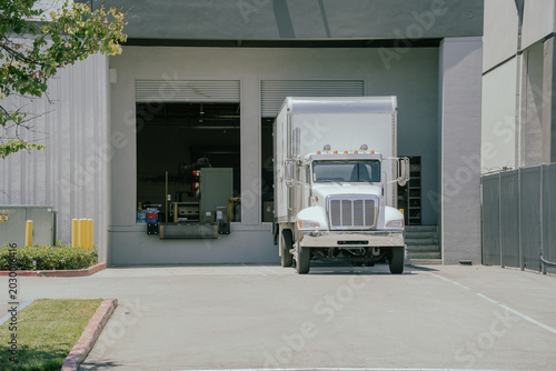 Fotografi Delivery truck parked by a loading dock in a commercial area