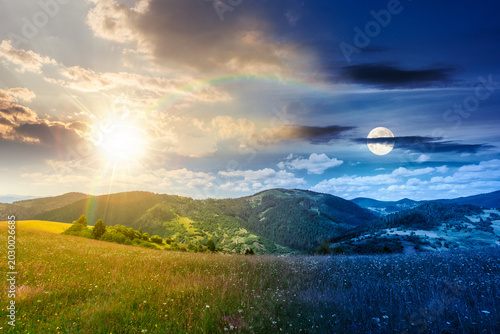 day meet night. mountainous countryside landscape on summer solstice. grassy field on a hillside. view of a forested mountain ridge in the distance. wonderful weather with cloudy sky. harmony concept