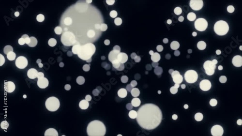 Luminous white and light grey particles gracefully drift and swirl against an infinite, deep black void, creating a dynamic 3D field with subtle bokeh and shallow depth of field, resembling ethereal