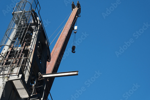 Cuadro en lienzo Industrial crane stands tall against a cloudless blue sky