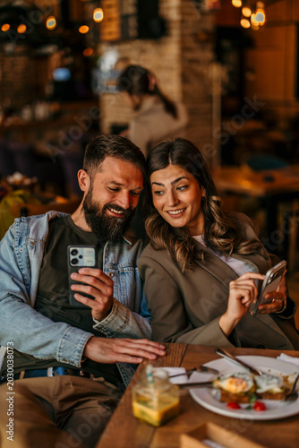 Foto Couple enjoying brunch and connecting with smartphones