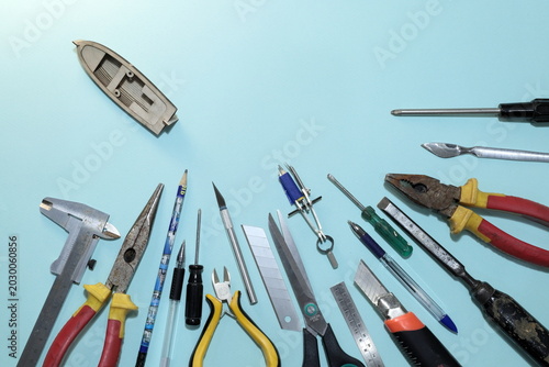 a boat model and a set of old tools on a blue background