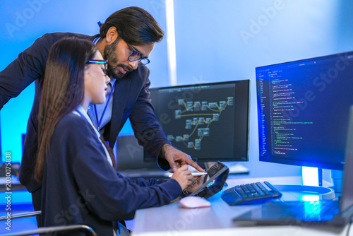 Bilde på lerret Chinese female hardware designer verifying microprocessor registers and memory bus workflows with an Indian manager at a corporate tech station