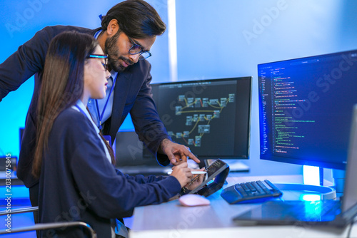 Foto Chinese female hardware designer verifying microprocessor registers and memory bus workflows with an Indian manager at a corporate tech station