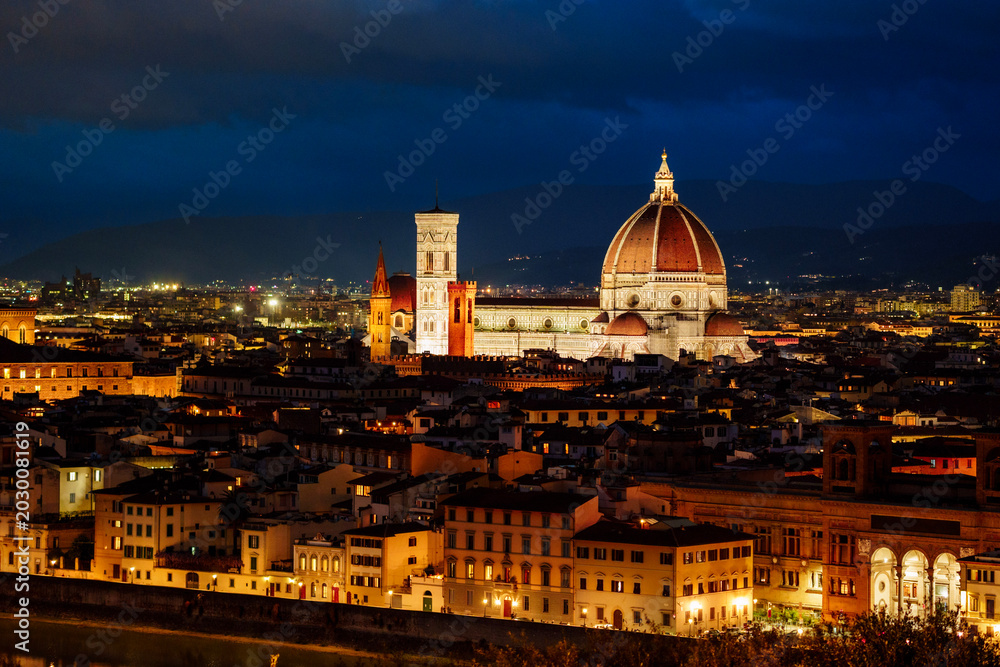 Fototapeta premium Wide angle night panorama of illuminated Florence historic center with glowing streets and Renaissance architecture lit up in warm golden light