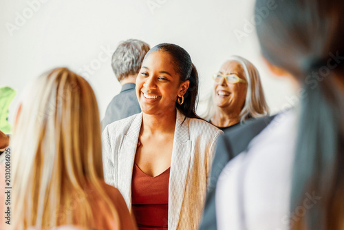 Foto Smiling Black businesswoman networking with diverse professionals